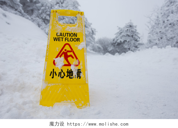冬天雪地里立着一块黄色的警示牌警告警告标志牌上雪楼